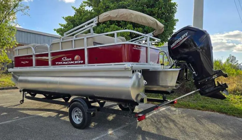 Slide: The Image of 2025 Sun Tracker Party Barge 18 DLX pontoon boat with Mercury outboard engine on trailer. - 9