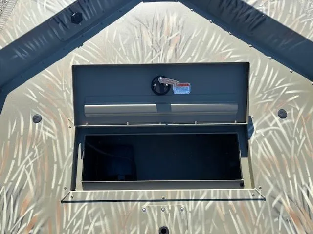 Slide: The Image of 2024 Tracker Grizzly 1648 SC boat storage compartment with camouflage pattern. - 5