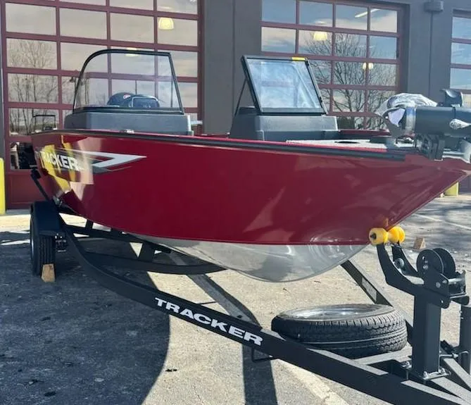 Slide: The Image of 2025 Tracker Pro Guide V-175 WT boat on trailer, red exterior, parked outside. - 2