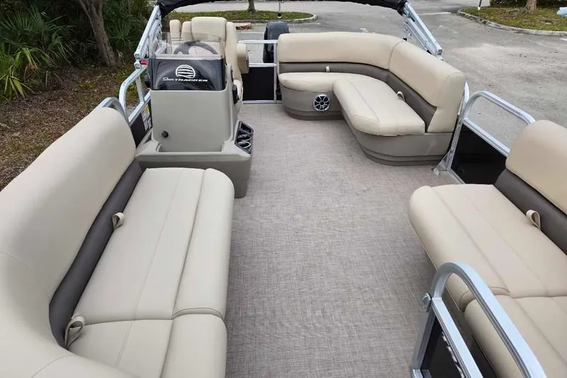 Slide: The Image of 2025 Sun Tracker Party Barge 16 DLX interior with beige seating and spacious layout. - 3