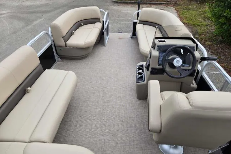 Slide: The Image of 2025 Sun Tracker Party Barge 16 DLX interior with beige seating and steering console. - 6