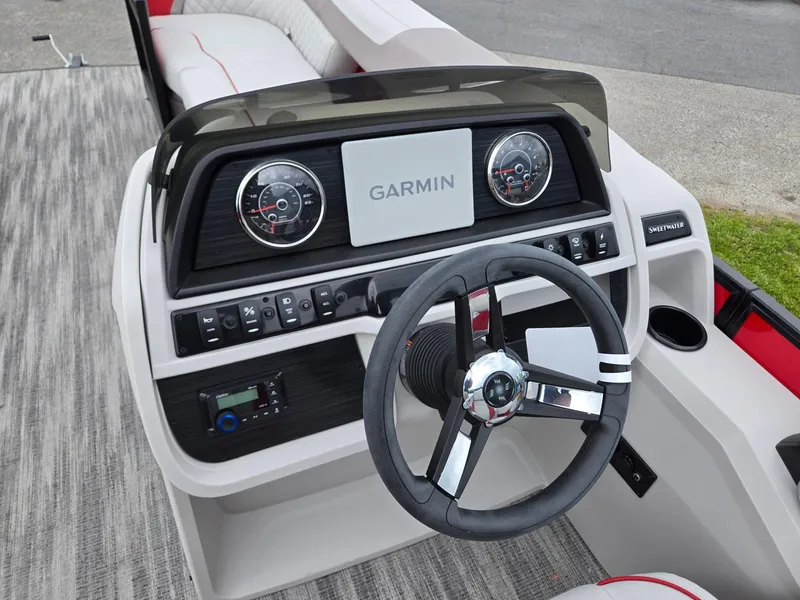 Slide: The Image of 2025 Godfrey SWEETWATER 2286 SFL boat dashboard with Garmin display and steering wheel. - 12