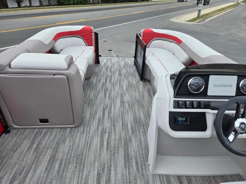 Slide: The Image of 2025 Godfrey SWEETWATER 2286 SFL boat interior with plush seating and Garmin dashboard. - 27