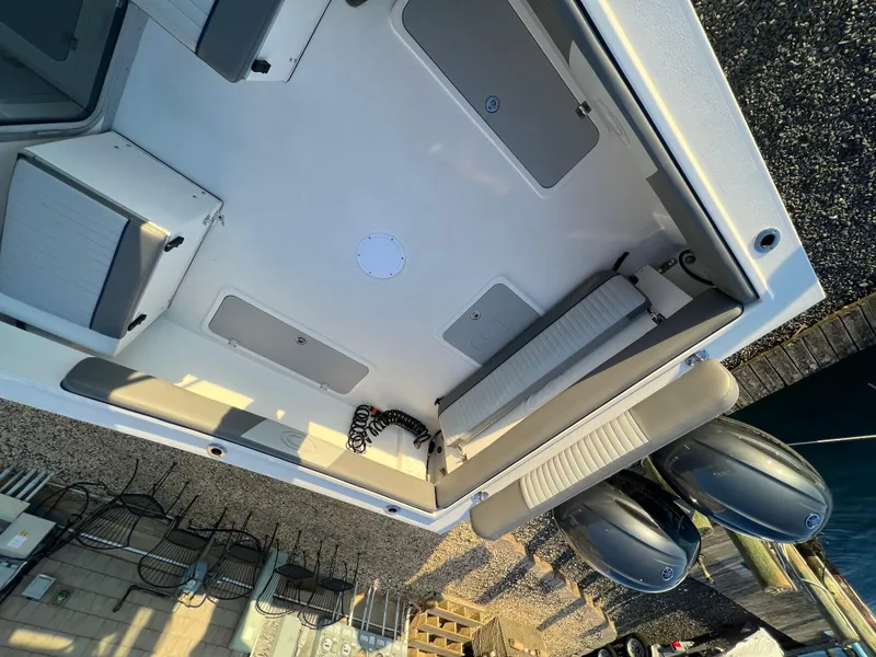 Slide: The Image of 2025 Defiance Admiral 220 EX boat interior with seating and dual outboard motors. - 14