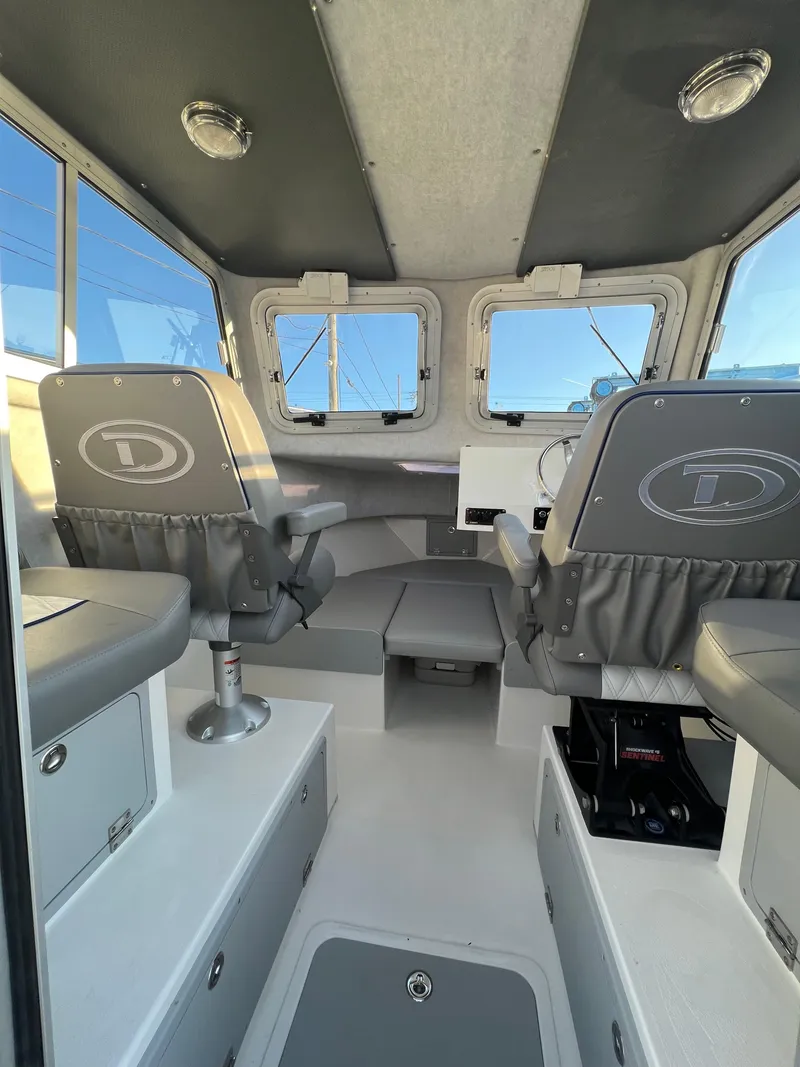 Slide: The Image of 2025 Defiance Admiral 220 EX boat interior with modern seating and dashboard. - 17
