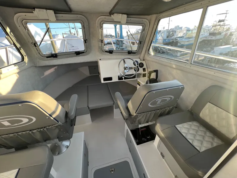 Slide: The Image of Interior of 2025 Defiance Admiral 220 EX boat, featuring seating and steering area. - 18
