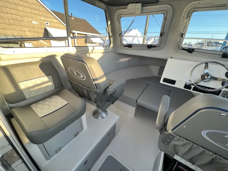 Slide: The Image of Interior of 2025 Defiance Admiral 220 EX boat with modern seating and steering wheel. - 19
