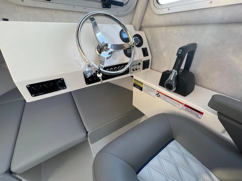 Slide: The Image of Interior of 2025 Defiance Admiral 220 EX boat, featuring steering wheel and control panel. - 21
