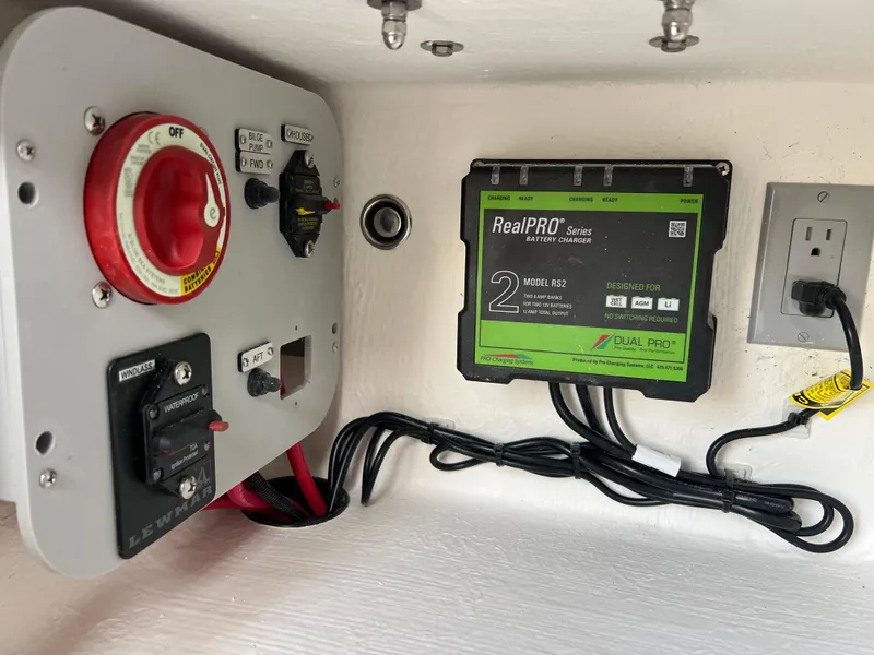 Slide: The Image of Electrical panel and battery charger in a 2025 Defiance Admiral 220 EX boat. - 25