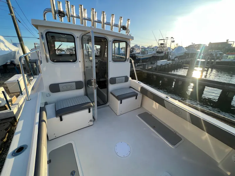 Slide: The Image of 2025 Defiance Admiral 220 EX boat docked, showcasing spacious deck and seating. - 27