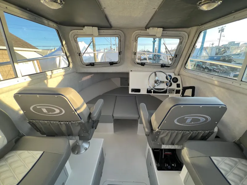 Slide: The Image of Interior of 2025 Defiance Admiral 220 EX boat with modern seating and steering console. - 28