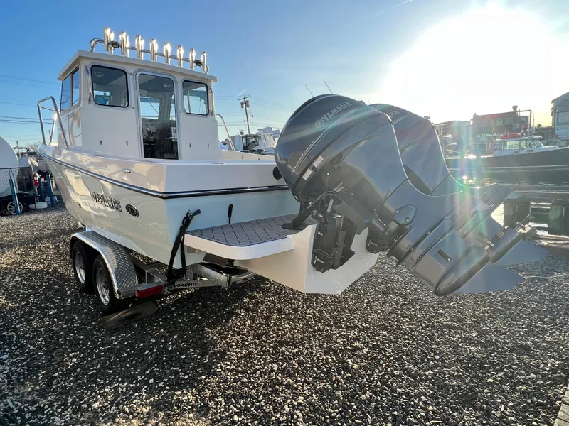 Slide: The Image of 2025 Defiance Admiral 220 EX boat with outboard motor on a trailer, sunny day. - 3
