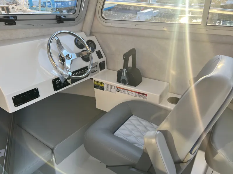 Slide: The Image of Interior of 2025 Defiance Admiral 220 EX boat with steering wheel and seating. - 32