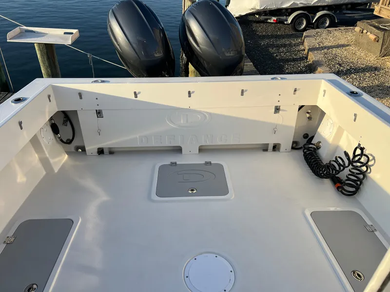 Slide: The Image of 2025 Defiance Admiral 220 EX boat deck with twin outboard motors. - 9