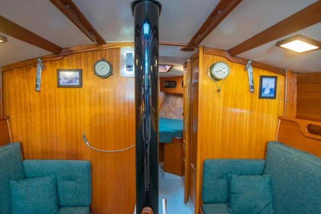 Slide: The Image of Interior of 1971 Ericson 39 Flush Deck sailboat with wood paneling and teal seating. - 16