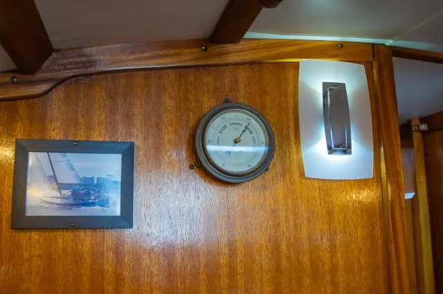 Slide: The Image of Wooden interior of 1971 Ericson 39 Flush Deck with barometer and framed sailboat photo. - 17