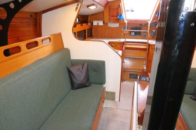 Slide: The Image of 1971 Ericson 39 Flush Deck sailboat interior with wood finish and green seating. - 20