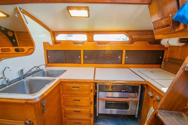 Slide: The Image of 1971 Ericson 39 Flush Deck yacht kitchen with wood cabinetry and stainless steel sink. - 27