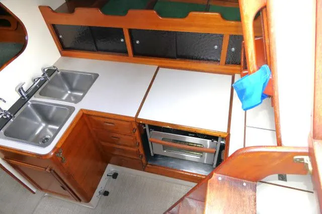 Slide: The Image of 1971 Ericson 39 Flush Deck yacht kitchen with dual sinks and wooden cabinetry. - 28
