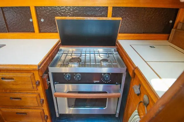 Slide: The Image of 1971 Ericson 39 Flush Deck yacht kitchen with stove and wooden cabinetry. - 31