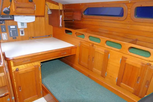 Slide: The Image of 1971 Ericson 39 Flush Deck interior with wooden cabinetry and green cushioned seating. - 34