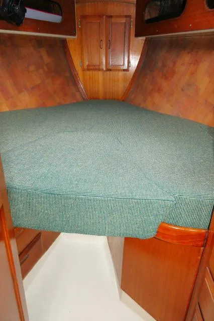 Slide: The Image of 1971 Ericson 39 Flush Deck cabin interior with wooden finish and green bedspread. - 45
