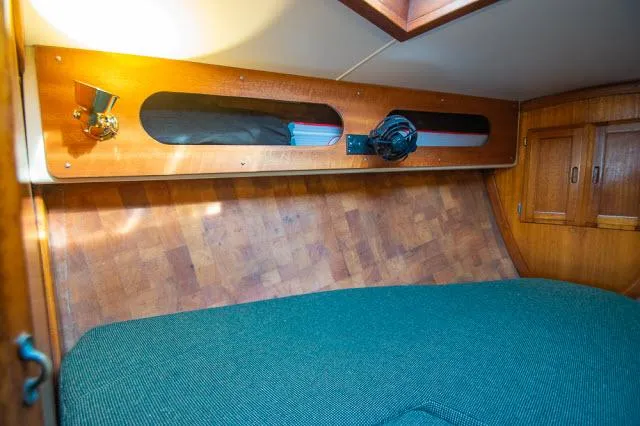 Slide: The Image of 1971 Ericson 39 Flush Deck cabin interior with wooden paneling and cozy bedding. - 49