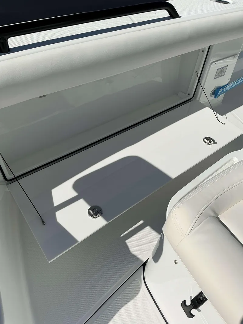Slide: The Image of 2025 Everglades 273 CC boat interior with white seating and storage compartment. - 10
