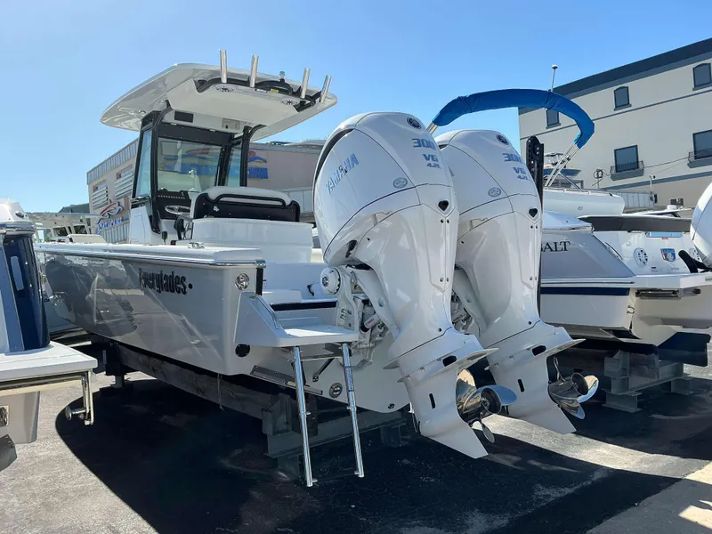 Slide: The Image of 2025 Everglades 273 CC boat with dual outboard engines in a marina setting. - 3