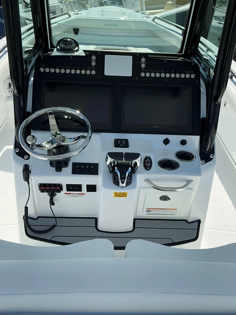 Slide: The Image of 2025 Everglades 273 CC boat dashboard with dual screens and steering wheel. - 5
