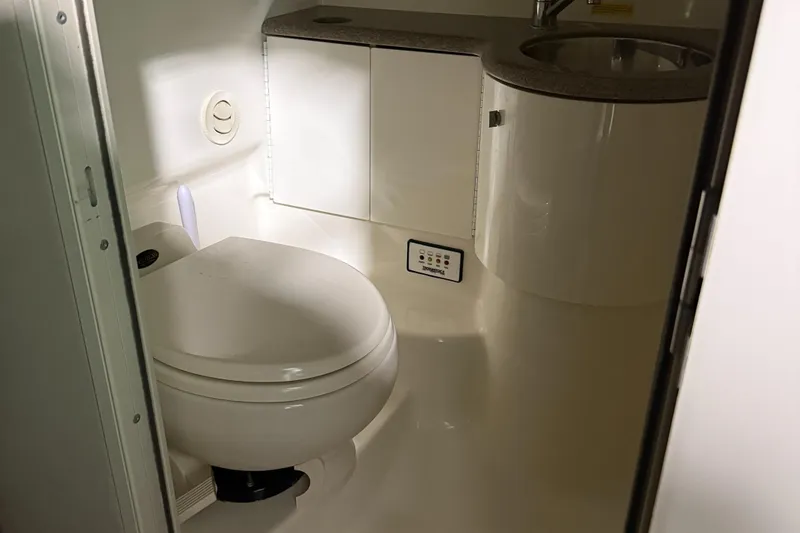 Slide: The Image of Compact bathroom in a 2002 Formula 400 Super Sport boat, featuring a toilet and sink. - 21