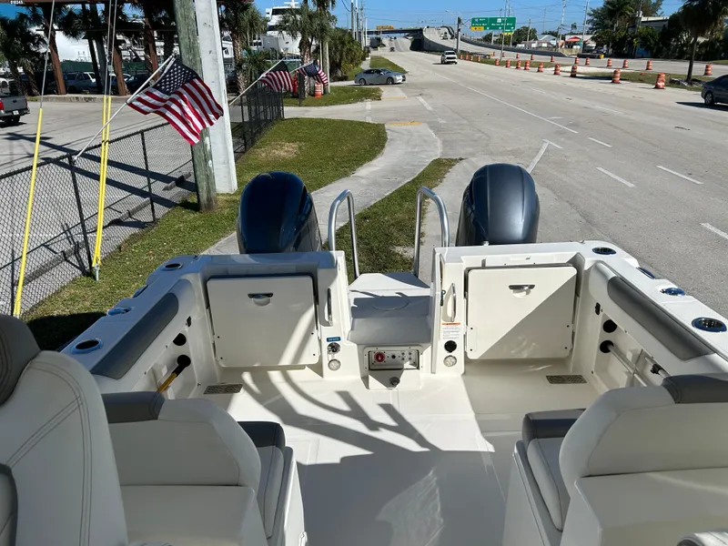 Slide: The Image of 2022 World Cat 255DC boat interior with dual engines, parked near a road. - 16