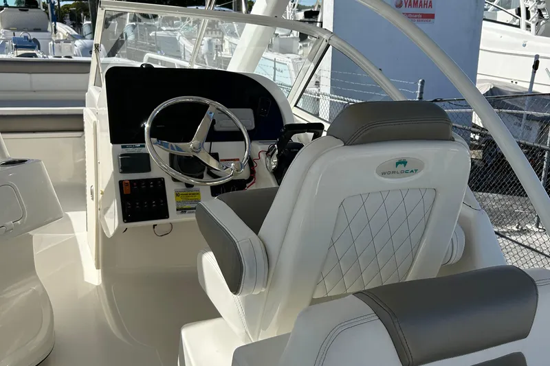 Slide: The Image of 2022 World Cat 255DC boat interior with steering wheel and captain's chair. - 20