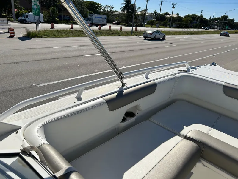 Slide: The Image of 2022 World Cat 255DC boat interior with seating, parked near a road. - 22