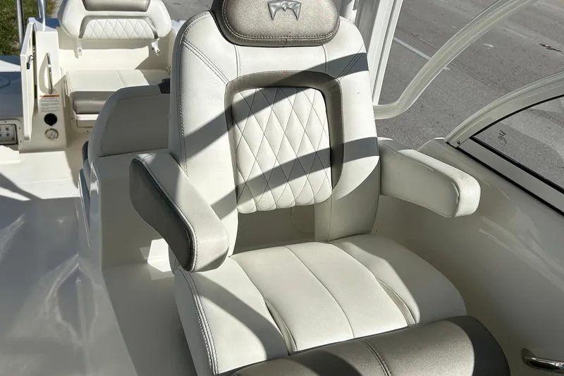 Slide: The Image of Luxurious seating on 2022 World Cat 255DC boat, featuring elegant white upholstery and armrests. - 24