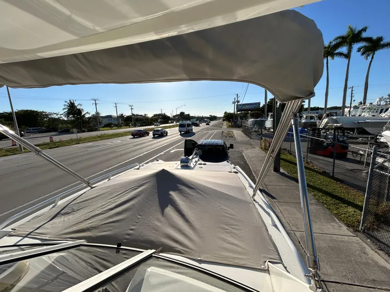 Slide: The Image of World Cat 255DC boat on trailer, roadside view, sunny day, palm trees in background. - 8