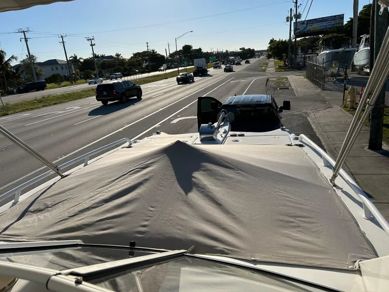 Slide: The Image of World Cat 255DC boat on trailer, parked beside a busy road, 2022 model. - 9