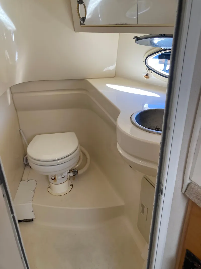Slide: The Image of 2000 Larson Cabrio 290 boat bathroom with toilet and sink. - 11