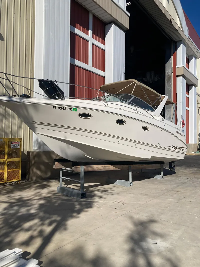 Slide: The Image of 2000 Larson Cabrio 290 boat on stand outside storage facility. - 19