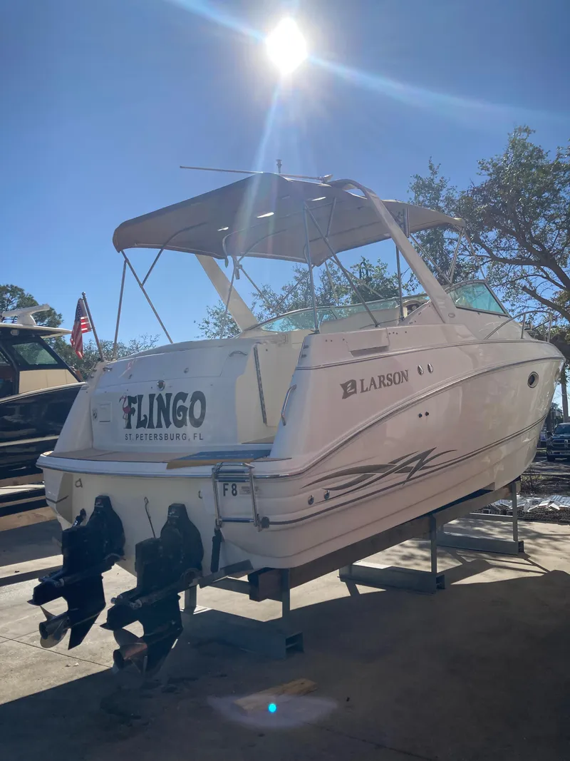 Slide: The Image of 2000 Larson Cabrio 290 boat on trailer under bright sun. - 21