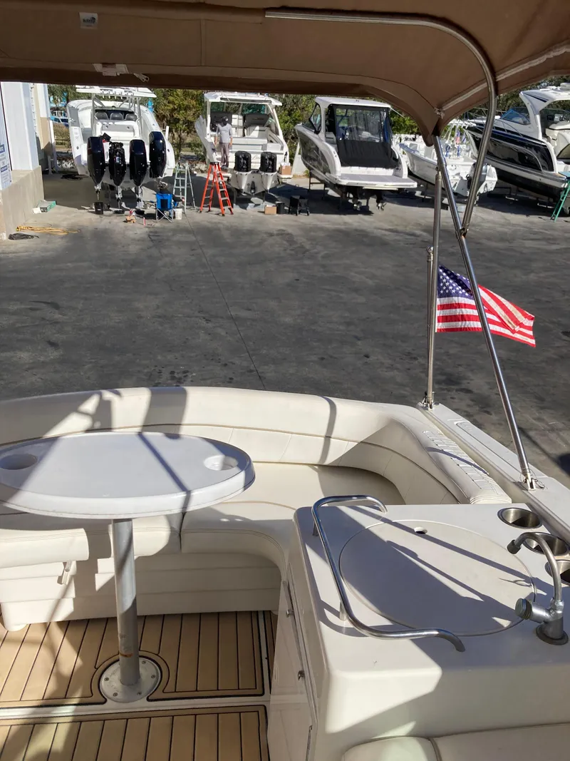 Slide: The Image of 2000 Larson Cabrio 290 boat interior with American flag, docked near other boats. - 23