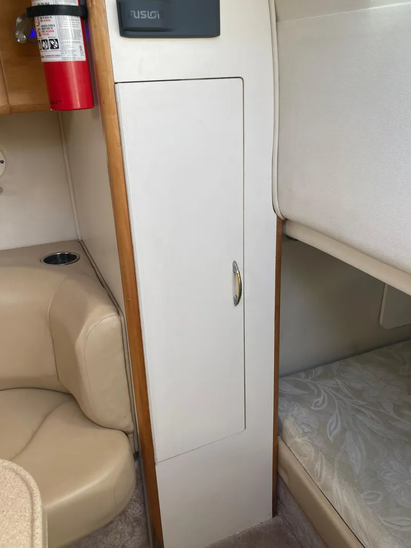 Slide: The Image of Interior of 2000 Larson Cabrio 290 boat with seating, storage, and fire extinguisher. - 4