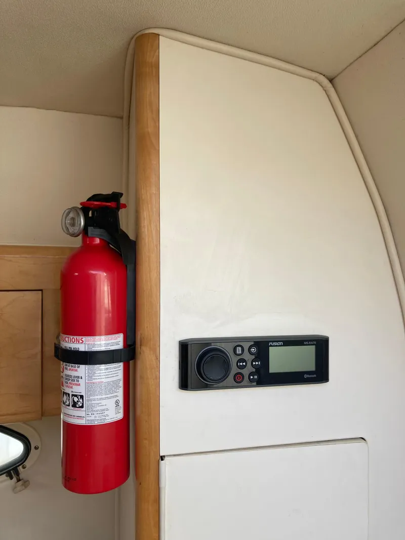 Slide: The Image of Fire extinguisher and control panel inside 2000 Larson Cabrio 290 boat cabin. - 6