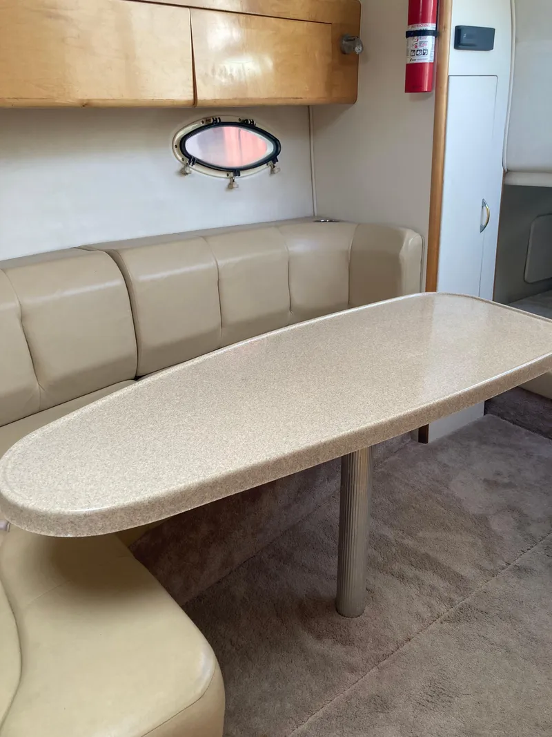 Slide: The Image of Interior of 2000 Larson Cabrio 290 boat with beige seating and table. - 9