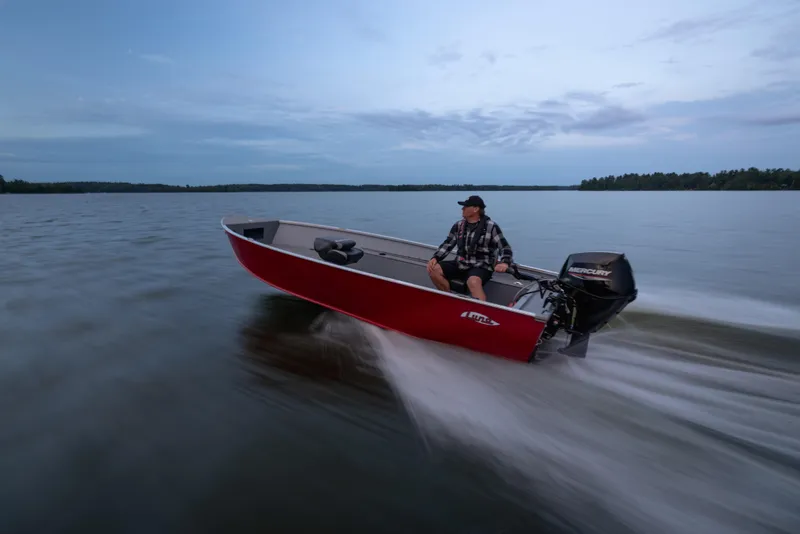 Slide: The Image of 2025 Lund 1600 Fury Tiller boat speeding on a lake at dusk. - 5