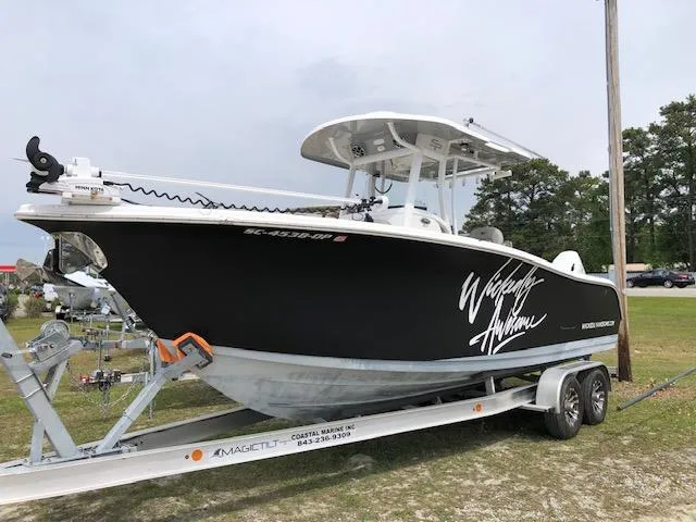 Slide: The Image of 2021 Sea Pro 259 DLX boat on trailer, black hull, parked outdoors. - 1
