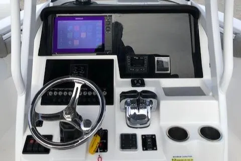 Slide: The Image of 2021 Sea Pro 259 DLX boat dashboard with steering wheel and navigation controls. - 14