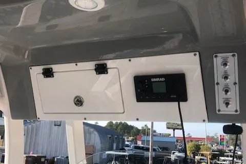 Slide: The Image of 2021 Sea Pro 259 DLX boat dashboard with Simrad electronics and storage compartment. - 18