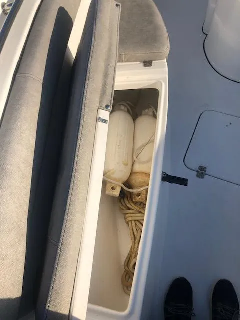 Slide: The Image of 2021 Sea Pro 259 DLX boat storage compartment with ropes and fenders. - 22
