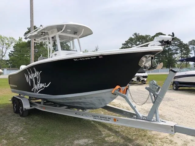 Slide: The Image of 2021 Sea Pro 259 DLX boat on trailer, black hull, parked outdoors. - 3